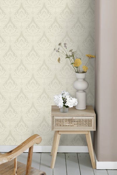 Szene mit gemusterter Tapete und einem kleinen Beistelltisch mit Blumenvasen.