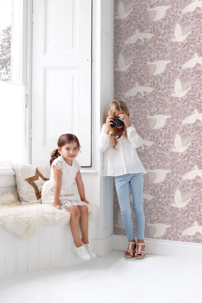 Tapete mit Schwanen- und Pflanzenmotiven in einem hellen Kinderzimmer mit zwei Mädchen.