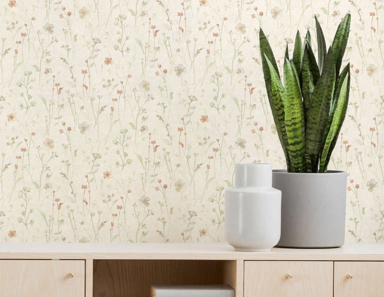 Tapete mit floralem Wiesenblumenmuster auf Holzkommode mit Pflanze in Topf und Vase.