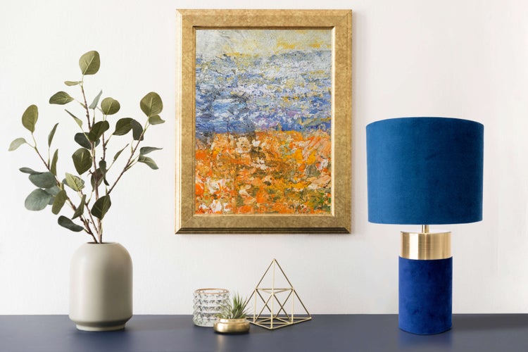 Dekoratives Stillleben mit Kunstgemälde, Tischleuchte und Zimmerpflanze