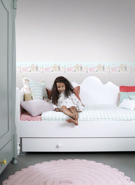 Kinderzimmer mit Bett, Kissen, Teppich und Bordüre mit Zirkusmotiven