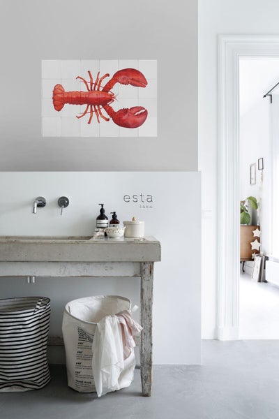 Heller Raum mit Waschbecken und Wandfliesen mit Hummer-Motiv