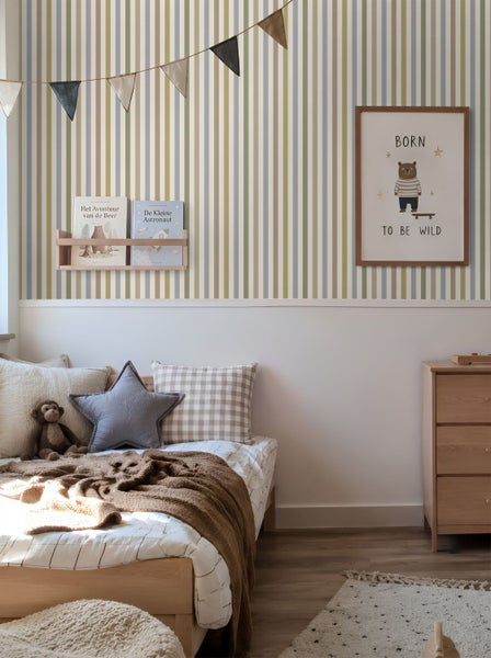 Gestreifte Tapete mit vertikalen Streifen in einem hellen Kinderzimmer mit Holzbett und Kommode.