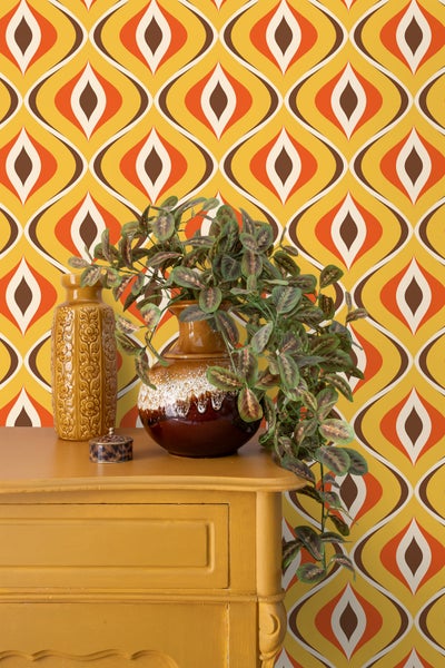 Dekorative Szene mit Retro-Tapete, Kommode, Vasen und Zimmerpflanze für ein stimmungsvolles Interieur