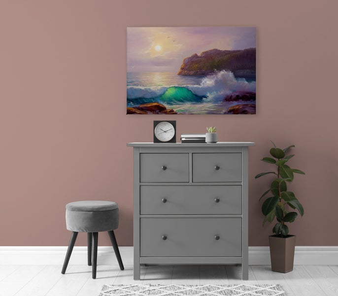 Wandbild mit einer Küstenlandschaft über einer grauen Kommode mit Hocker und Pflanze in einem modern eingerichteten Raum.