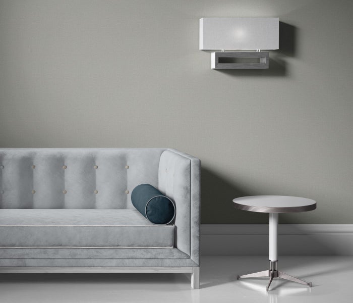 Ein Schlafzimmer mit einer blumigen Tapete, einem Bett mit einer weißen Decke und einem kleinen Beistelltisch.