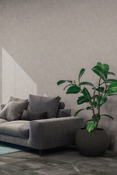 Wohnszene mit blumiger Tapete, Rattansessel und Beistelltischen