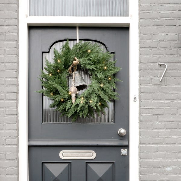 Dekorativer Türkranz mit Glocke und Beleuchtung an einer Haustür