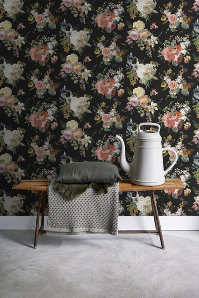 Dekorative florale Tapete mit Teekanne und Kissen auf einer Bank