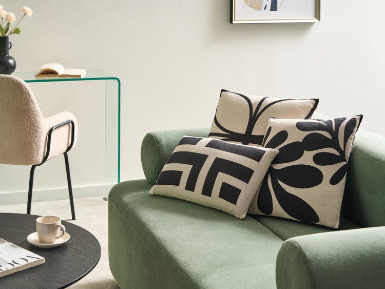 Wohnzimmer mit Sofa und dekorativen Kissen mit grafischen Mustern