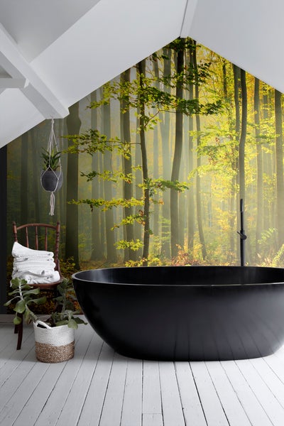 Badezimmer mit freistehender Badewanne, Waldtapete und Dekorationen