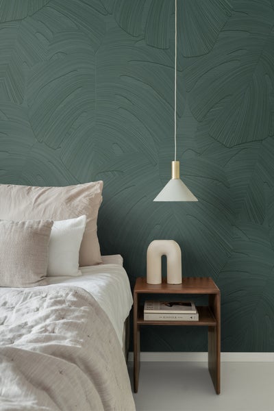 Schlafzimmer mit gemusterten Tapeten, Bett und Nachttisch