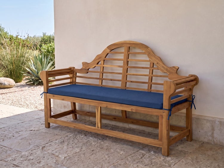 Gartenbank aus Holz mit geschwungener Rückenlehne und Sitzpolster auf einer Terrasse.