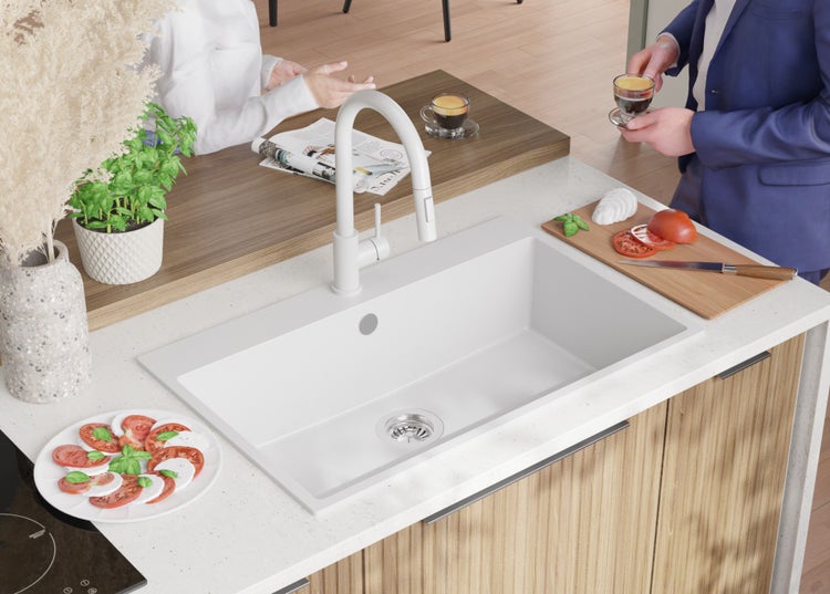 Küchenszene mit Spüle, Armatur und kulinarischen Zutaten auf einer Küchentheke.