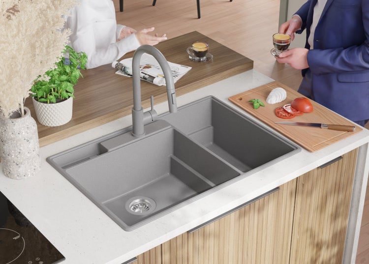 Küchenszene mit grauer Spüle, Armatur, Schneidebrett und Lebensmitteln auf einer Küchentheke.