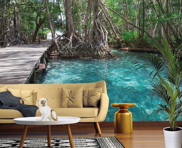 Modernes Wohnzimmer mit einer Fototapete, die einen tropischen Mangrovenwald mit Steg und klarem, türkisblauem Wasser zeigt.