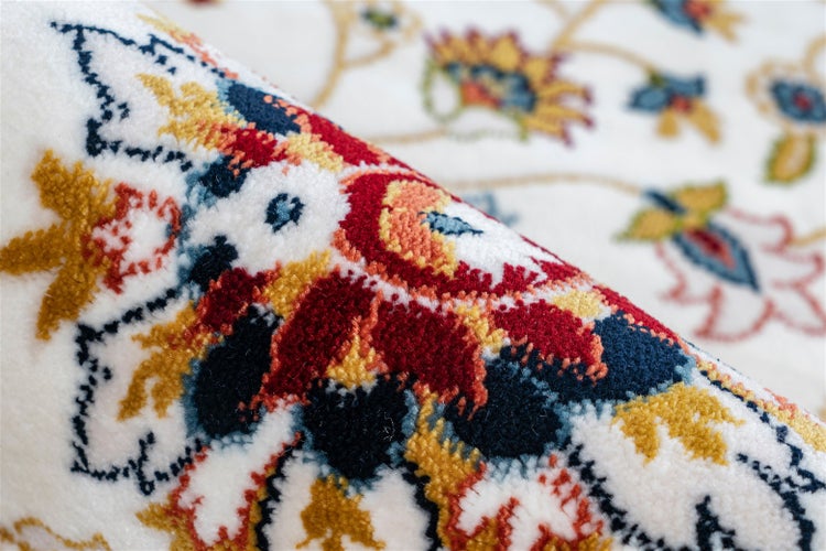 Detailaufnahme eines Teppichs mit buntem floralem Muster.