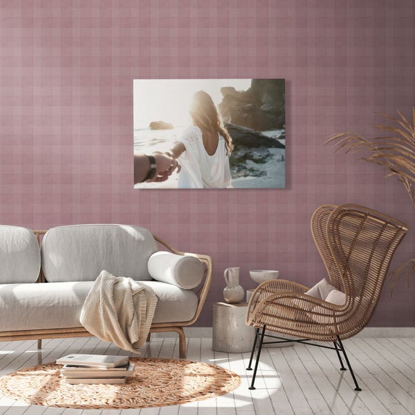 Wohnzimmer mit Sofa, Sessel und einem Wandbild mit Strandmotiv