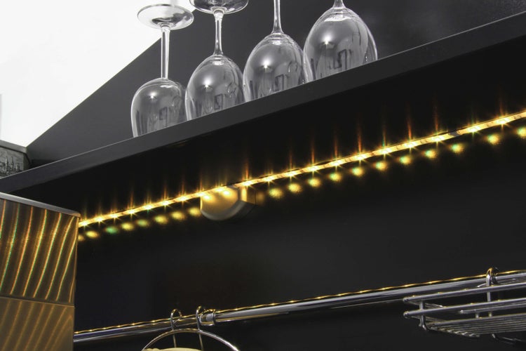 Detailansicht einer Bar mit LED-Beleuchtung und Gläsern auf einem Regal