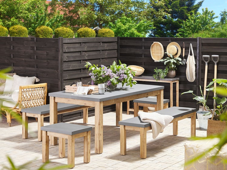 Gartenmöbel-Set mit Tisch, Bänken und Hockern auf einer Terrasse
