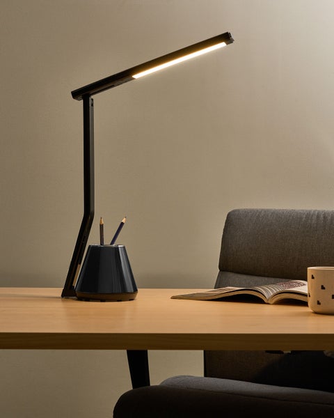 Schreibtisch mit LED-Lampe, Stifthalter, Buch und Tasse