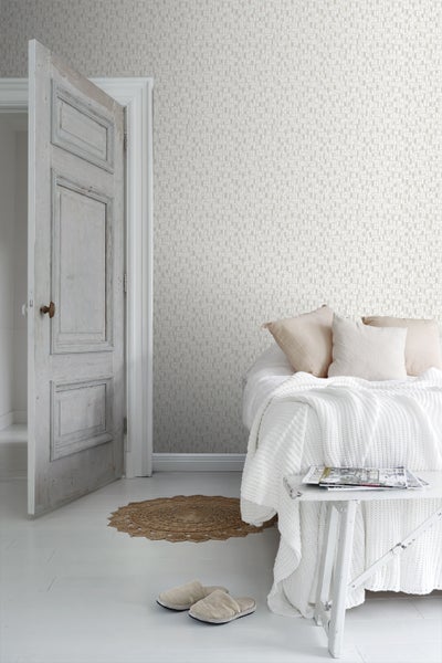 Helles Schlafzimmer mit gemusterter Tapete, offenstehender Tür und weiß gestrichenem Holzboden