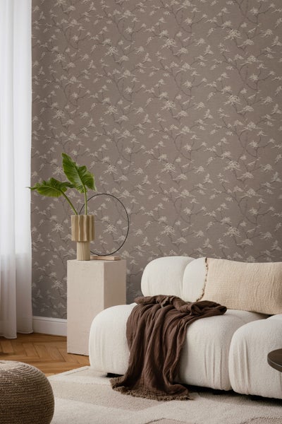 Schlafzimmer mit gemusterter Tapete, Rattanbett und Nachttisch mit Lampe, Uhr, Statue und Pflanzen