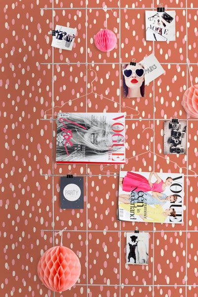 Dekorative Wand mit Zeitschriften und Fotos, befestigt an einem Gitter