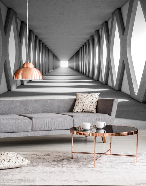 Fototapete mit 3D-Effekt in Betonoptik, langer Tunnel mit Säulen, in einem modernen Wohnzimmer mit grauem Sofa und Kupfertisch.