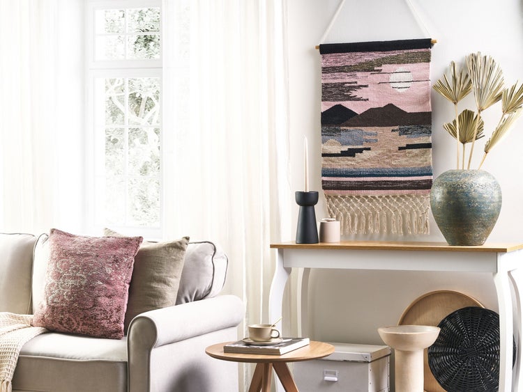 Helles Wohnzimmer mit Sofa, Tisch, Dekoration und Wandteppich