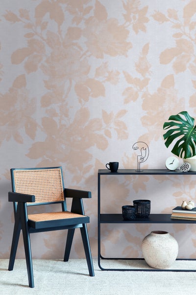 Vliestapete mit großflächigem Blumenmuster in einem modern gestalteten Wohnzimmer mit schwarzem Stuhl und Metallregal.