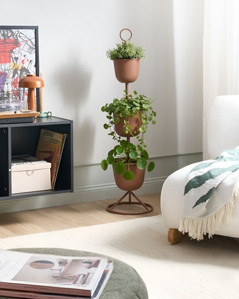 Dreistöckiger Pflanzenständer aus Metall mit Pflanzen in einem hellen Raum
