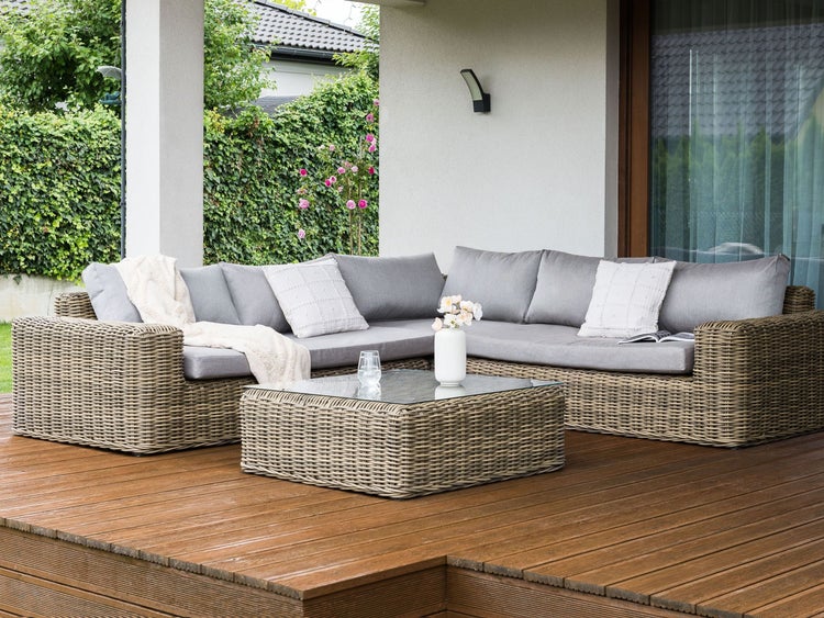 Gartenlounge-Set mit Rattansofa und Tisch auf Holzterrasse
