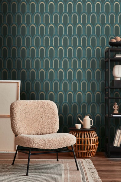 Wohnzimmer mit gemusterter Tapete, Sessel, Beistelltisch und Regal