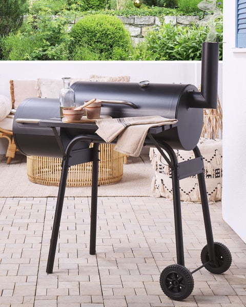 Yucca rostrata mit strukturiertem Stamm und strahlenförmigen, spitzen Blättern in Pflanztöpfen in einer Gärtnerei.