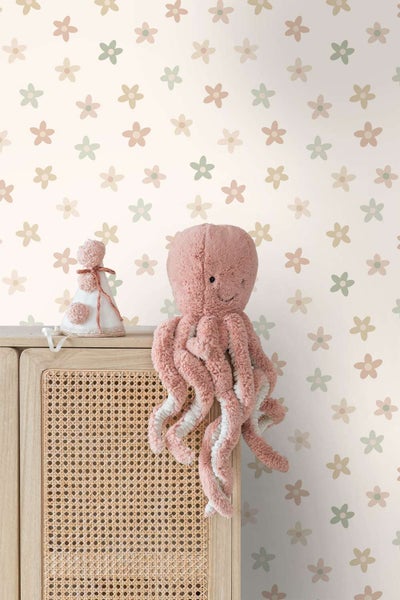 Vliestapete mit Blumenmuster vor einem Holzschrank mit Rattangeflecht und Stofftieren im Kinderzimmer