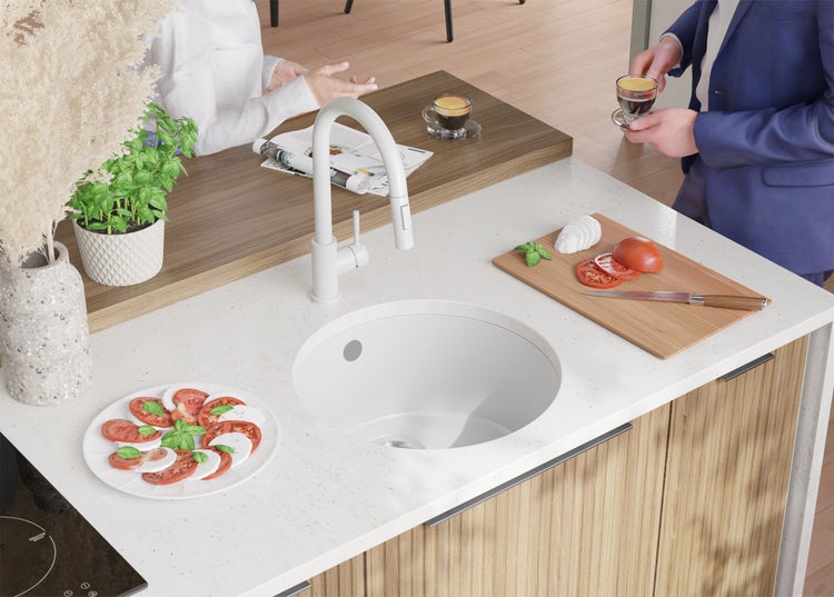 Küchenszene mit Spüle, Armatur, Speisen und Personen