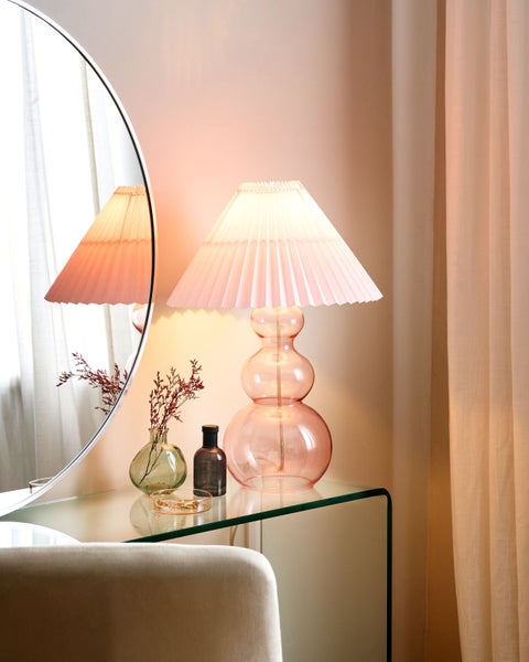 Dekorative Szene mit Lampe, Spiegel und Accessoires auf einem Schminktisch