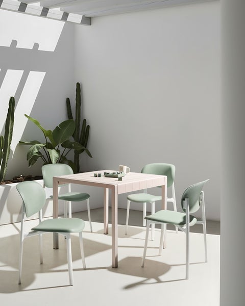 Quadratischer Tisch mit vier Stühlen in hellem Design für den Gartenbereich