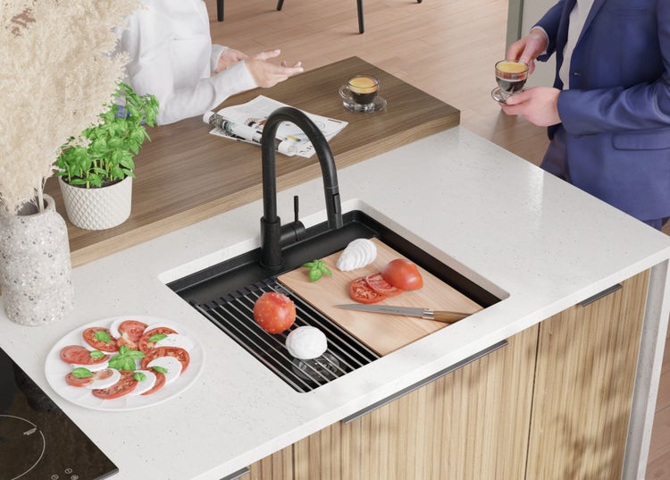 Küchenszene mit Spüle, Armatur, Schneidebrett und Zutaten für Caprese