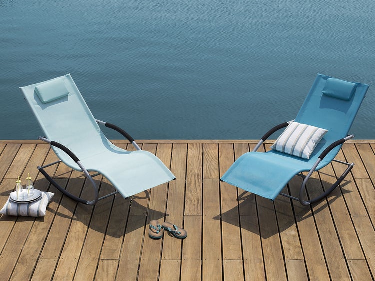 Zwei Gartenliegen auf einer Holzterrasse am Wasser.
