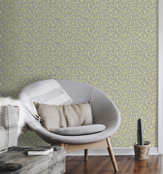 Raumansicht mit gemusterter Tapete, Sessel und Beistelltisch