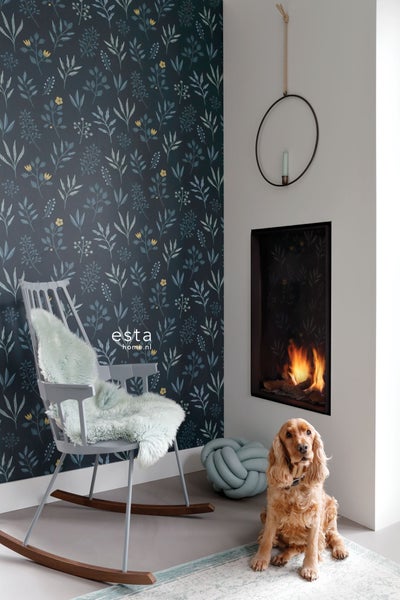 Wohnzimmer mit botanischer Tapete, Kamin, Schaukelstuhl mit Kissen und Hund