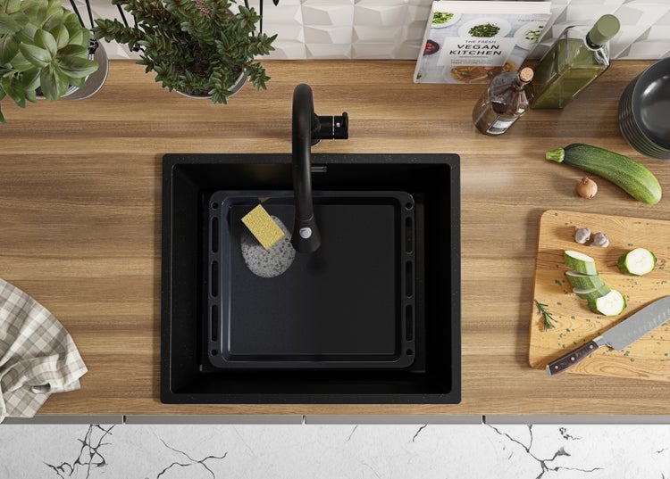 Küchenspüle mit Armatur, Backblech und Spülschwamm auf einer Arbeitsplatte