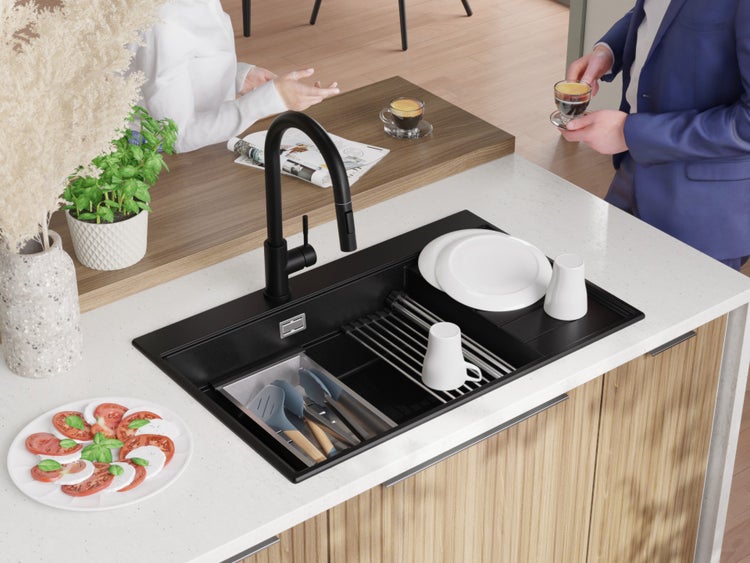 Küchenspüle mit Abtropfgestell, Geschirr und Armaturen auf einer Küchentheke.