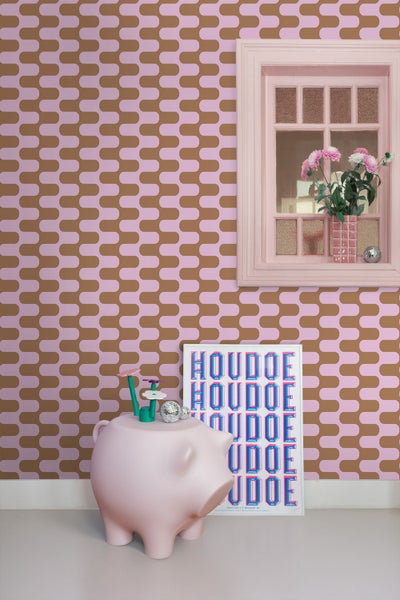 Ein Zimmer mit gemusterter Tapete, Fenster, Dekoration und einer Spardose in Schweinchenform.