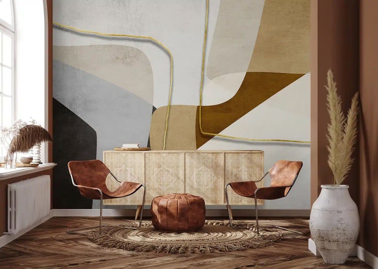 Abstrakte Fototapete mit geometrischen Formen und metallischen Linien im Wohnzimmer mit Holzsideboard und Ledersesseln.