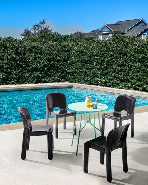 Gartenszene mit einem runden Tisch und vier Stühlen aus Kunststoff am Pool