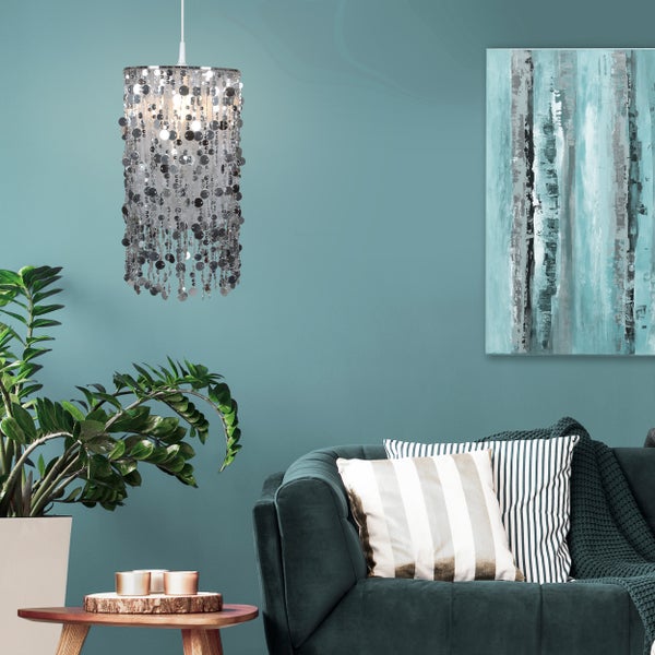 Szene mit einer Hängeleuchte mit Pailletten, einem Sofa, einem Tisch und Dekoration