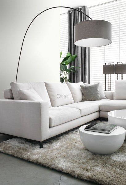 Wohnzimmer mit Ecksofa, Stehlampe und runden Couchtischen auf einem Teppich